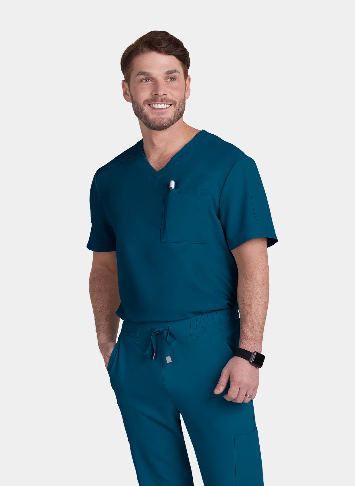 Men's Caribbean blue V-neck medical scrub top and scrub trousers, worn by a model with chest pocket and drawstring waist.
