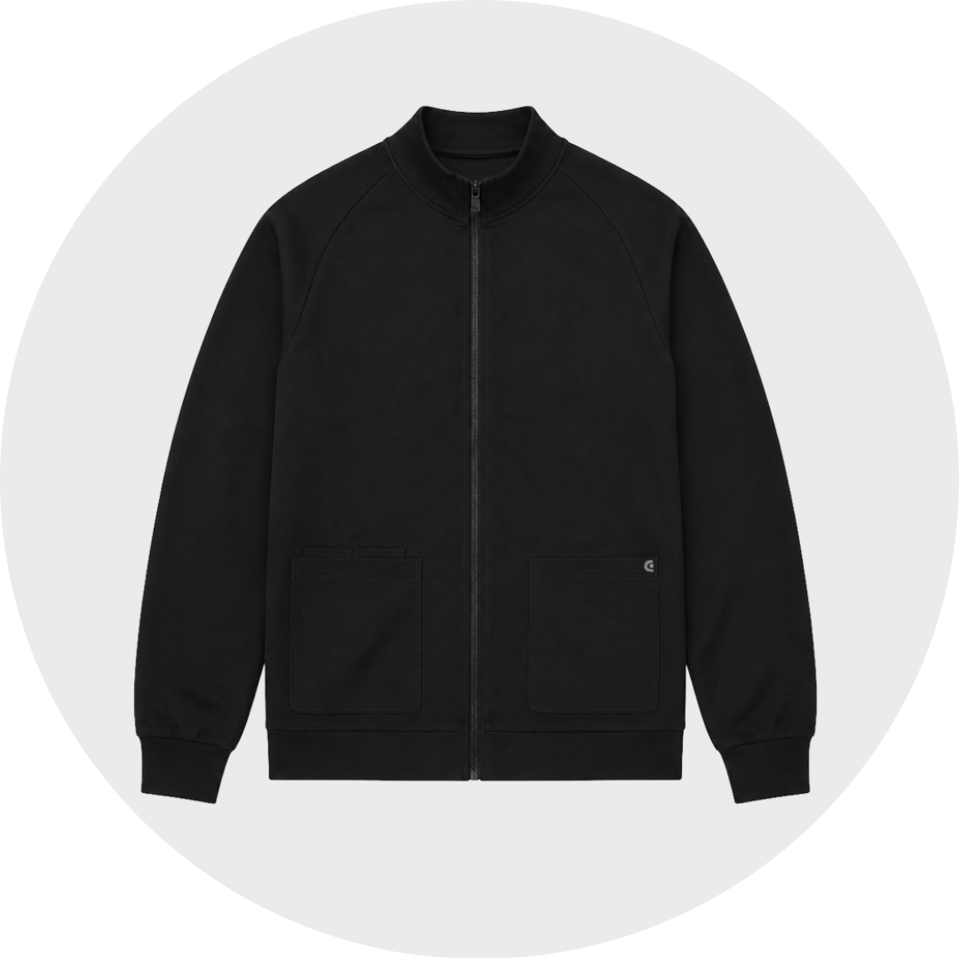 A black men's zip-up scrub jacket with a stand collar, ribbed cuffs and hem, and two lower front patch pockets with logo detail, shown flat against a light gray circular background.