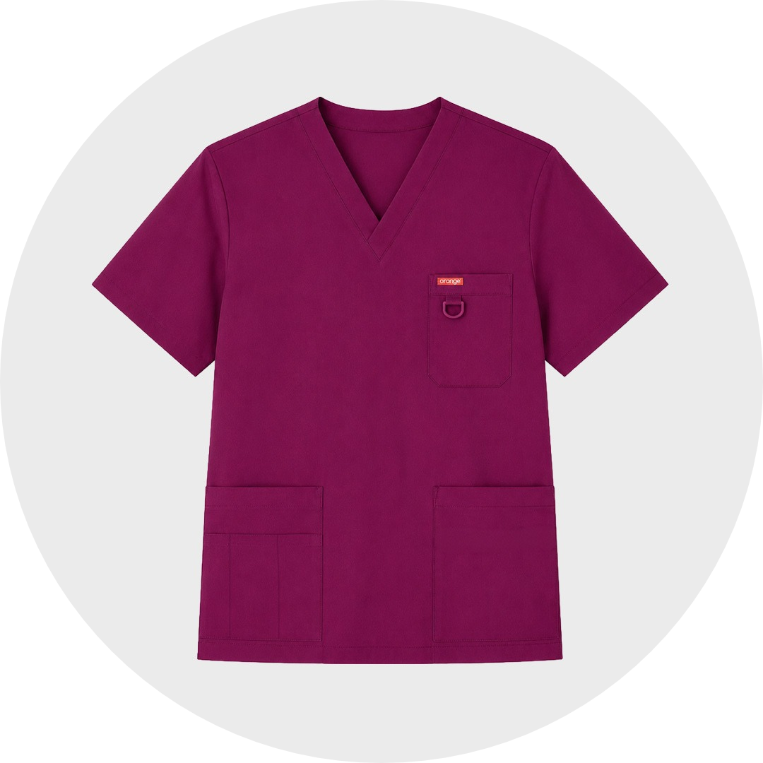Wine-colored standard scrub top with V-neck, chest pocket with D-ring, and two lower patch pockets, featuring Orange brand label, laid flat against a gray circular background.