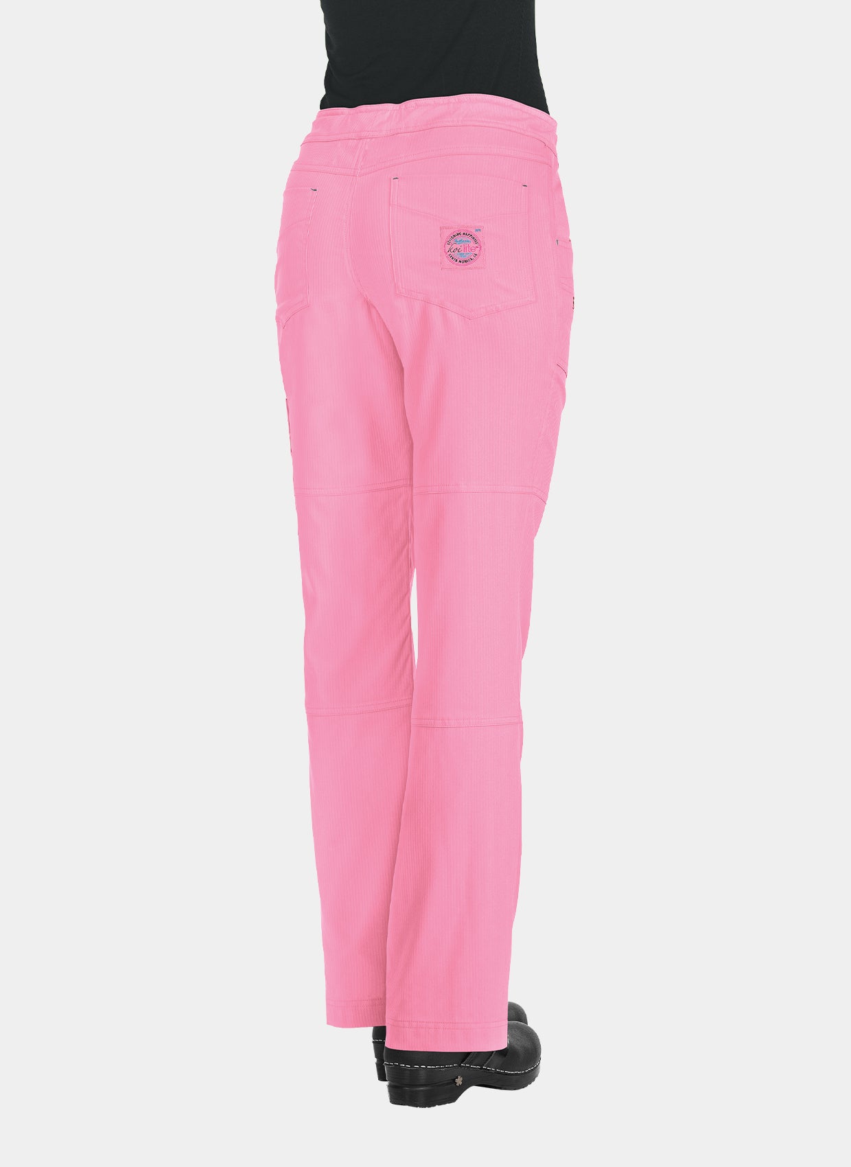 Women's pink straight-leg scrub trousers with back patch pockets and utility pockets, shown from the rear, worn by a model.
