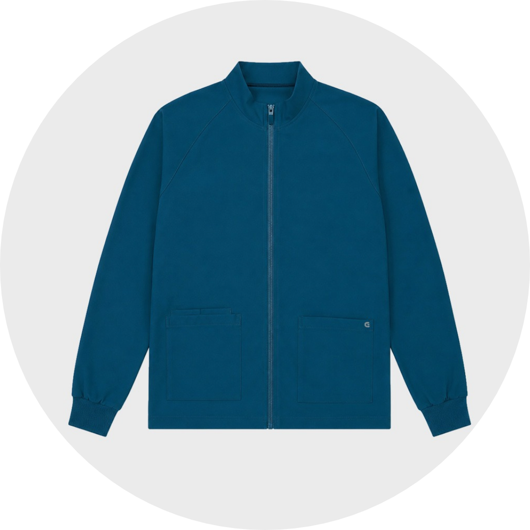 Teal blue zip-front plus size scrub jacket with stand collar, two front patch pockets, and ribbed cuffs, laid flat against a gray circular background.