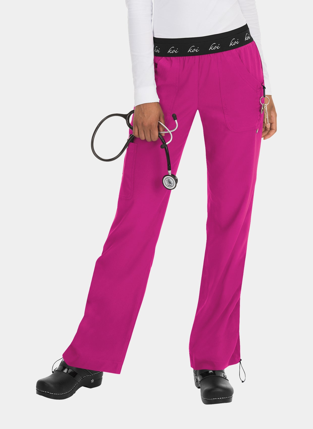 Women's bright pink straight-leg scrub trousers with elastic logo waistband, utility pockets, and adjustable hems, worn by a model.
