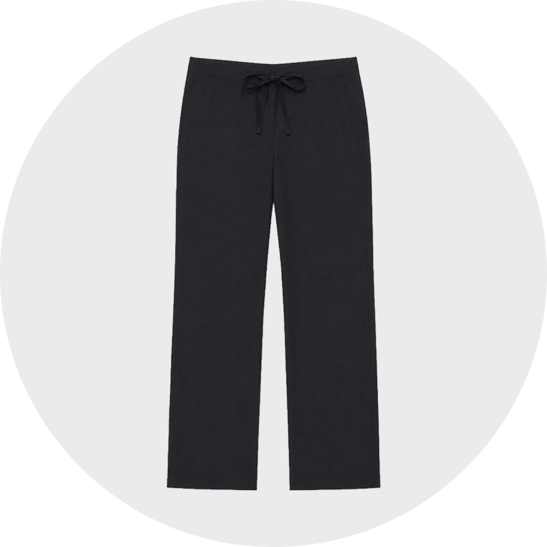 Black straight leg scrub trousers with an elastic drawstring waist and no visible pockets, shown flat against a light gray circular background.