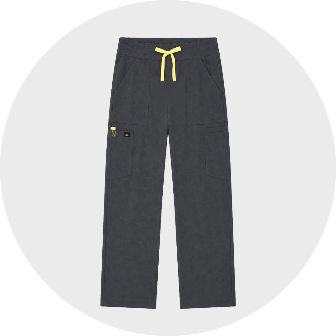 Charcoal gray veterinary scrub trousers with a yellow drawstring waist, two large front pockets, and a side cargo pocket with logo patch, shown flat against a light gray circular background.